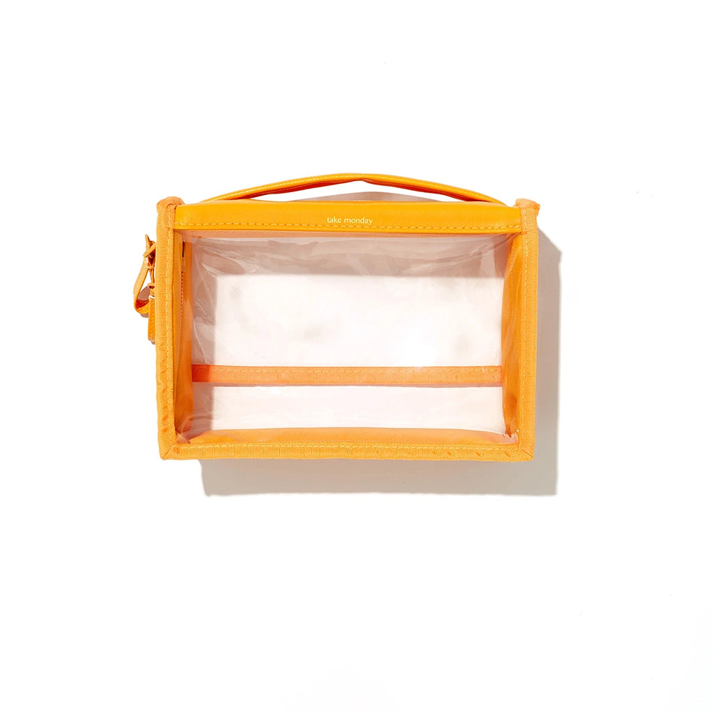A bright orange rectangular "take monday" clear PVC pouch featuring a top handle and gold zipper detail on a clean white background